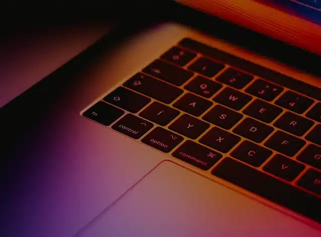 Illuminated laptop keyboard in darkness.